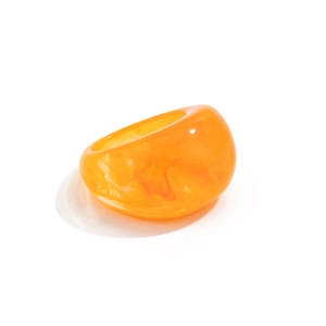 Nahaufnahme von klobigem orangem Harzring mit Marmor-Effekt und breitem Design