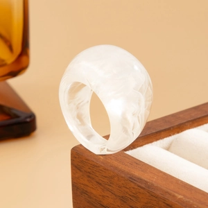 Detailansicht eines durchscheinenden Marmor-Harzrings auf einer Schmuckschatulle aus Holz