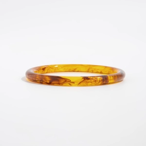 Vista dettagliata della trama in resina ambrata su questo ampio bracciale geometrico