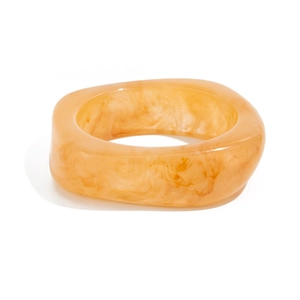 Macro shot of amber marbled resin bangle with wide square profile on white background