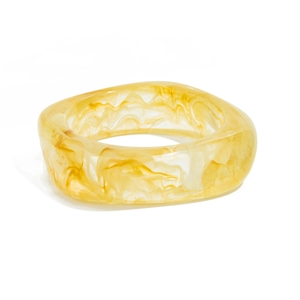 Close-up of yellow and white marble pattern wide resin bangle with transparent finish
