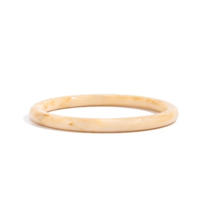 Macro detail of minimalist cream marble resin bangle with smooth vintage texture