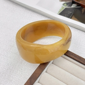 Dettaglio del bracciale largo in resina ambrata con venature naturali marmorizzate