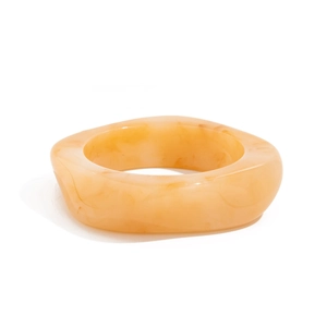 Macro di un bracciale in resina ambra traslucida con trama effetto marmo