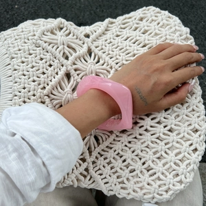 Pink translucent resin cuff bracelet with irregular geometric cut worn by model