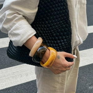 Set di tre bracciali rigidi in resina con trama marmorizzata in toni ambra e caffè