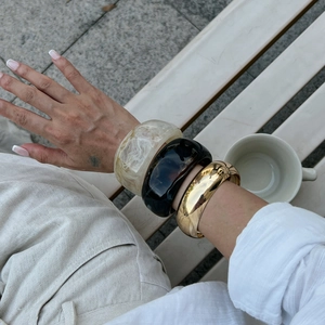 Chic layered look with marble resin, amber acrylic and gold metal wide bangles