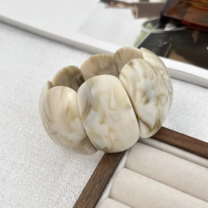 Detail of wide resin stretch bracelet with marble texture and geometric design