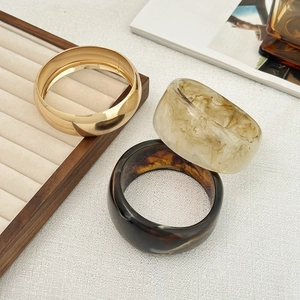 Detail showing vintage resin bangles with marble texture and golden metallic finish