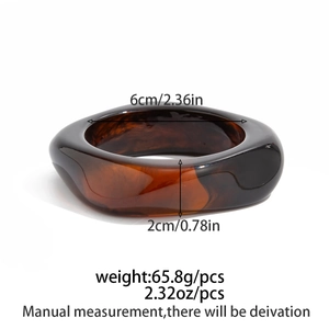 Detailed view of wide amber resin bangle with measurements of inner diameter and width
