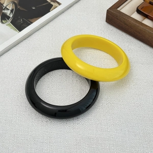 Minimalistische ronde hars armbanden in gepolijst geel en zwart met een geometrisch ontwerp