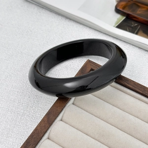 Macro-opname van gepolijste zwarte hars armband met hoogglans spiegelafwerking op display