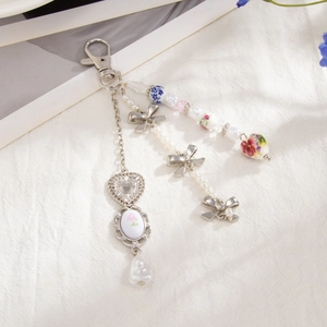 Detailed view of ceramic pearl keychain with floral heart pendant and bow charms