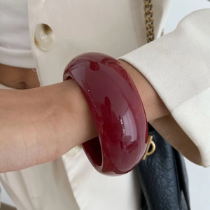 Deep burgundy resin bangle featuring a polished finish and irregular geometric wide design