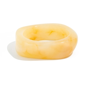 Macro view of wide translucent amber acrylic bangle with dark marble pattern texture