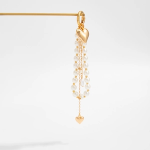 Close-up of gold heart pendant with elegant white pearl tassels for bags and keys