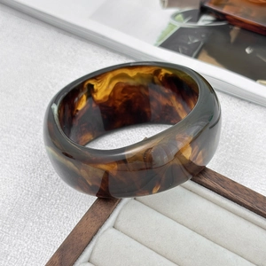 Detailed macro view of retro brown tortoiseshell resin bangle with marbled textures
