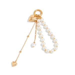 Detail of gold-plated alloy heart keychain with faux pearls and spring ring clasp