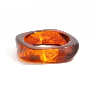 Macro shot of wide square resin bracelet featuring translucent amber marble texture