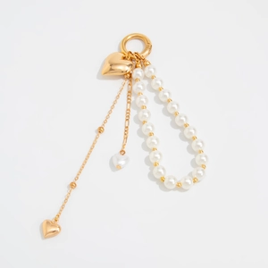 Golden heart pendant and pearl bead tassel keychain for bags on white background