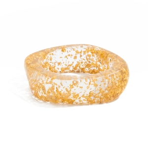 Close-up of translucent acrylic wide bangle with embedded gold foil flakes details
