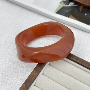 Detailed view of amber resin bangle with irregular shapes and translucent gold foil effect