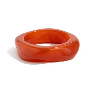 Detailed view of wide orange resin bangle with internal marble texture and rounded edges
