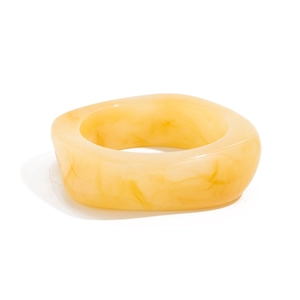 Detail of yellow marbled resin ring with thick square shape and smooth glossy finish