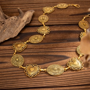 Detail of vintage gold waist chain with embossed heart and oval links on wood