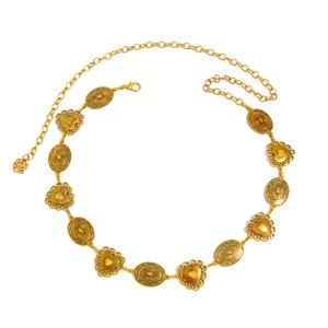 Detailed close-up of gold waist chain with embossed heart and oval turquoise patterns