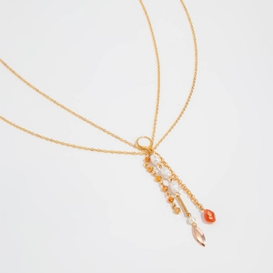 Detail of bohemian gold body chain with shell pearls and coral beads on white background
