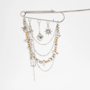Macro view of multi-layer tassel brooch with heart and star pendants on silver safety pin