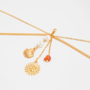 Detail of gold layered body chain with seashell, sun pendant and colorful beads