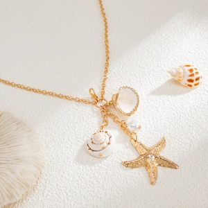 Detailed close-up of gold body chain featuring textured starfish and seashell pendants