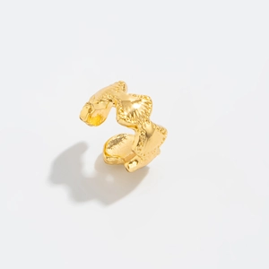 Detail van de gouden zeester-oorbel met getextureerd metalen oppervlak en zeeschelp