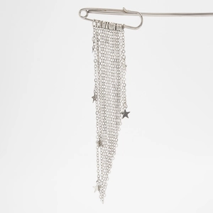 Close-up of silver safety pin brooch with star charms and long dangling metal tassels