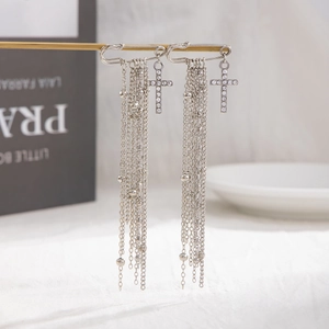 Dettaglio catena per pantaloni a spilla con croce di strass e lunghe nappe argentate