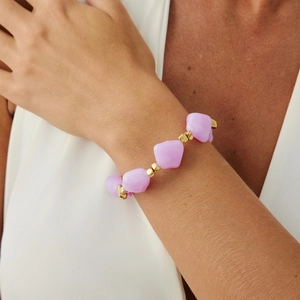 Close-up of irregular lavender crystal beads and gold metal spacers on a wrist