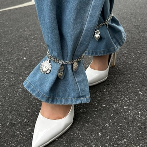 Silver pant chain with layered design and vintage flame heart pendants on blue denim