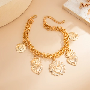 Detail of vintage gold layered chain featuring heart pendants with flame accents