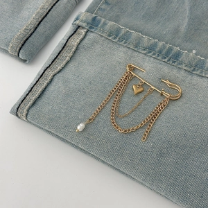 Gold heart brooch with multi-layer tassel chains and faux pearl on denim fabric