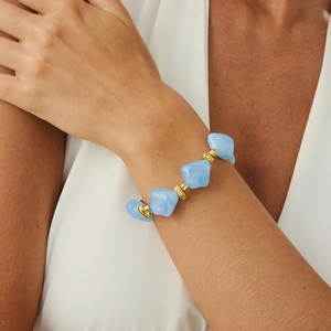 Detail view of light blue resin beads and gold spacers on a stylish beaded necklace