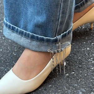 Punk style silver metal chain tassel brooch with star pendant on blue denim pants