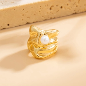 Gedetailleerd beeld van een gouden ring met textuur en witte parel op een steen