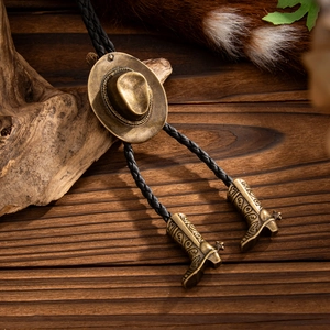 Detalle del lazo bolo con sombrero vaquero de bronce y botas sobre madera rústica