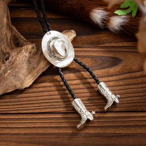 Detalle del pasador de sombrero vaquero plateado y dijes de botas en la corbata de bolo