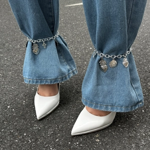 Cavigliera a doppia catena argento con ciondoli a cuore e croce sui jeans blu