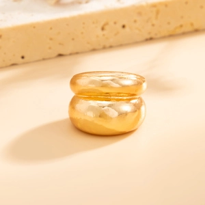 Macro-opname van gouden gelaagde ring met onregelmatig vloeiend ontwerp en spiegelglans