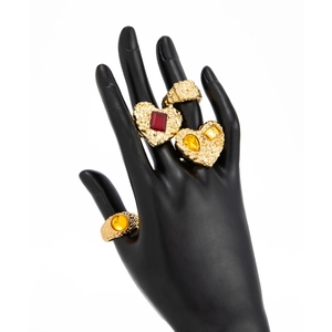 Detailaufnahme goldener Hammerschlag-Ringe mit bunten Edelsteinen auf einem Display