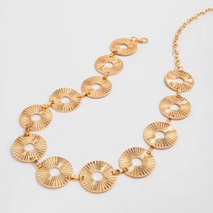 Detail of adjustable gold metal waist chain with sunburst textured circular links